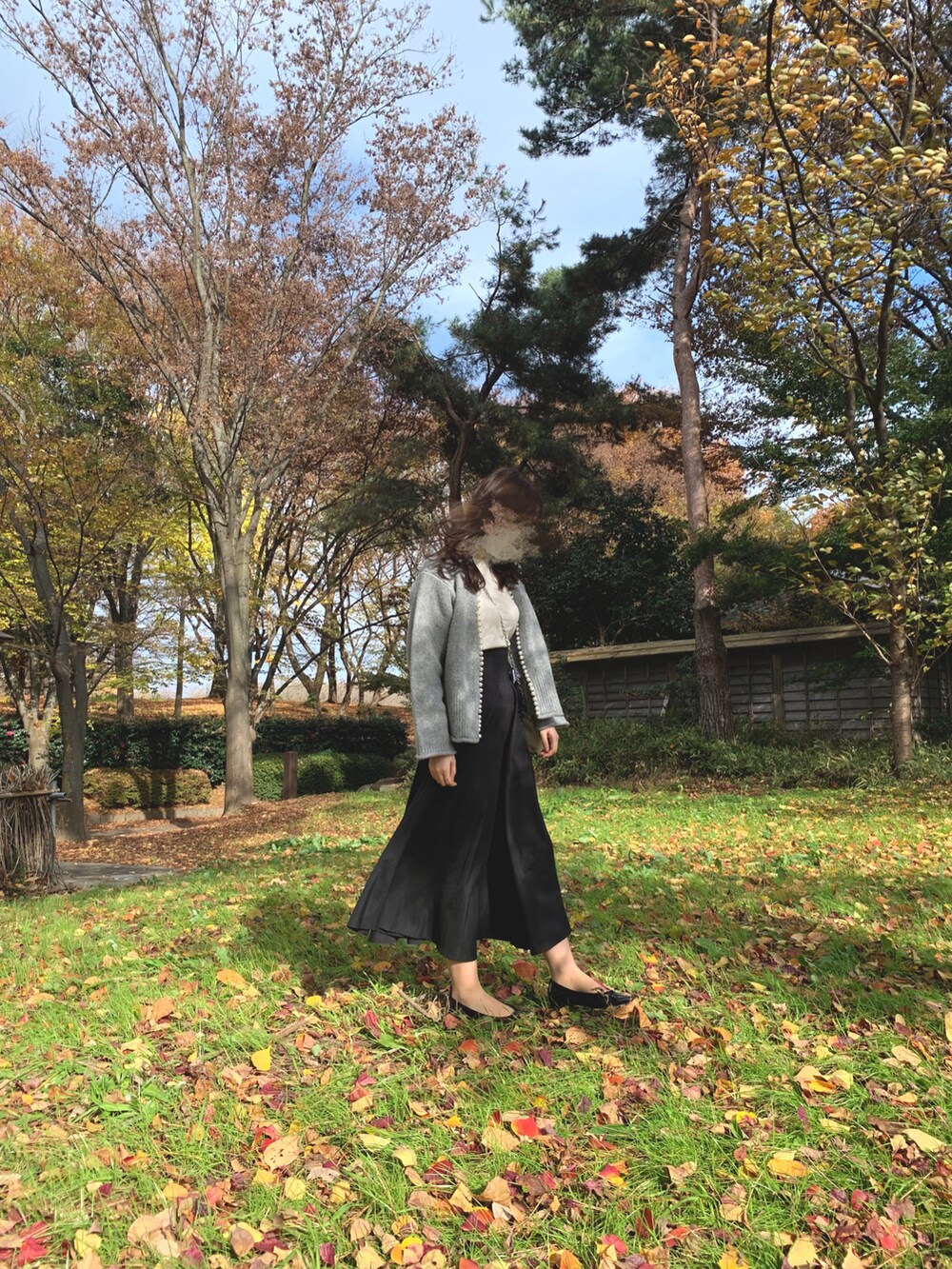 ホワイト系のニット/セーター、グレー系のジャケット/アウター、ブラック系のスカートを着用したレディースの秋コーディネートの2枚目の写真