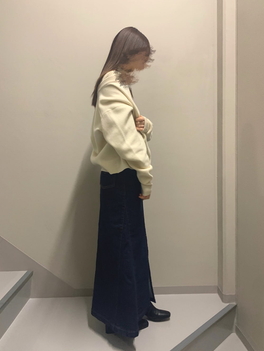 ホワイト系のカーディガン/ボレロ、ブラック系のニット/セーター、ブルー系のデニムスカートを着用したレディースの冬コーディネートの2枚目の写真