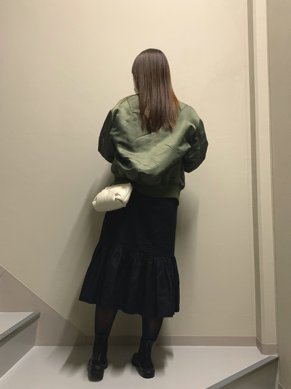 ブラック系のワンピース/ドレス、グリーン系のMA-1、ホワイト系のバッグを着用したレディースの冬コーディネートの3枚目の写真