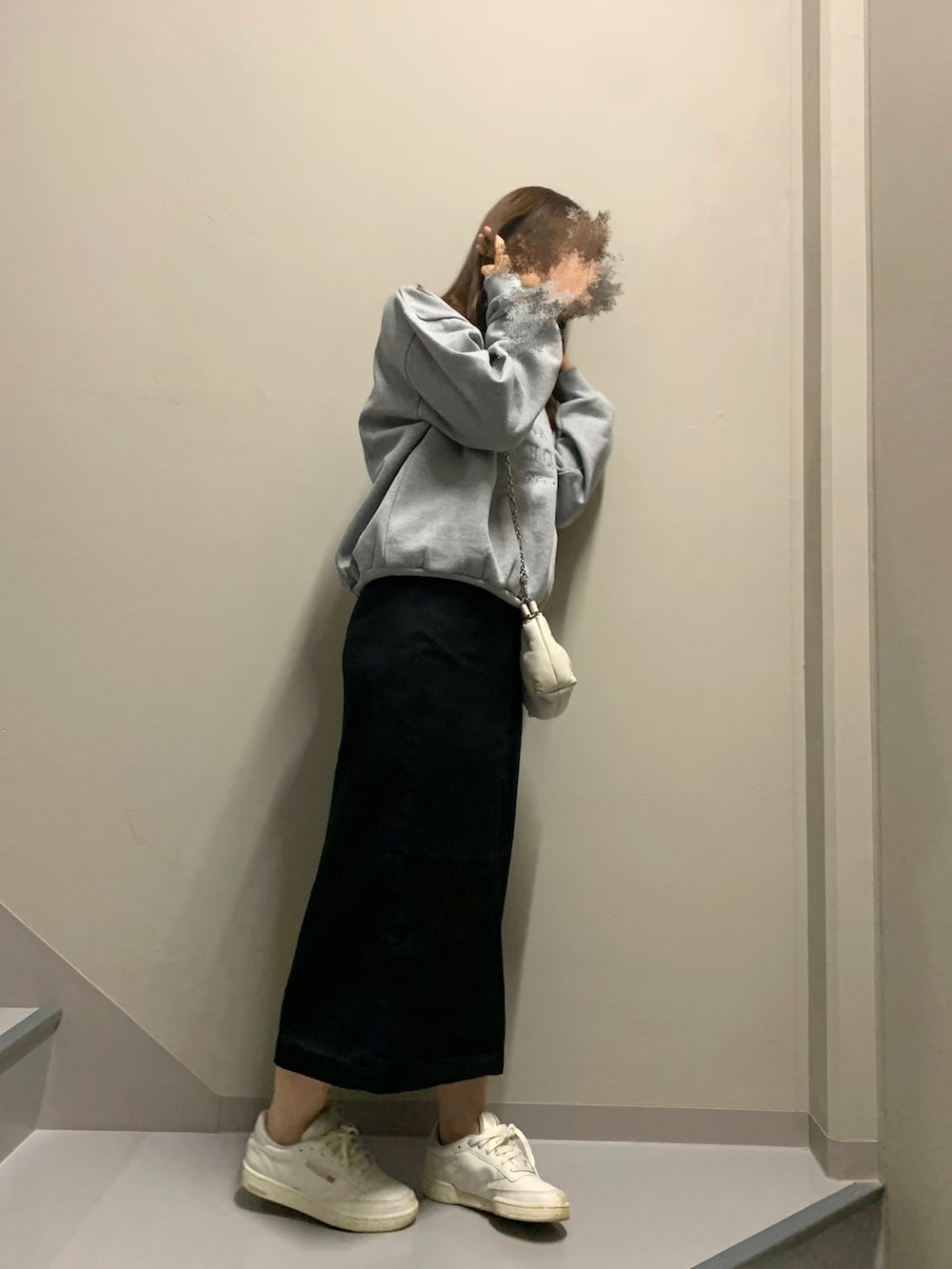 ブラック系のスカート、ホワイト系のスニーカー、ホワイト系のバッグを着用したレディースの冬コーディネートの3枚目の写真