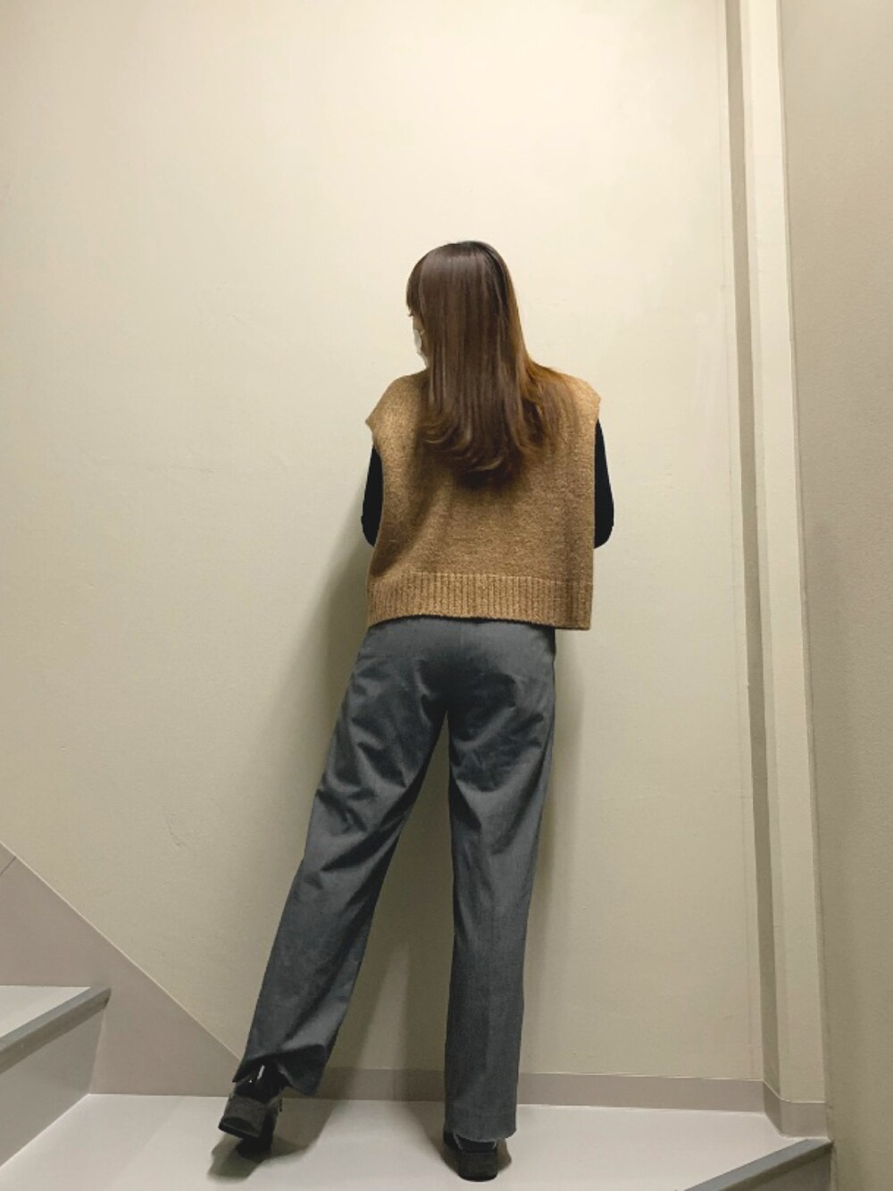 ブラウン系のベスト、グレー系のパンツ、ブラック系のシューズを着用したレディースの冬コーディネートの3枚目の写真