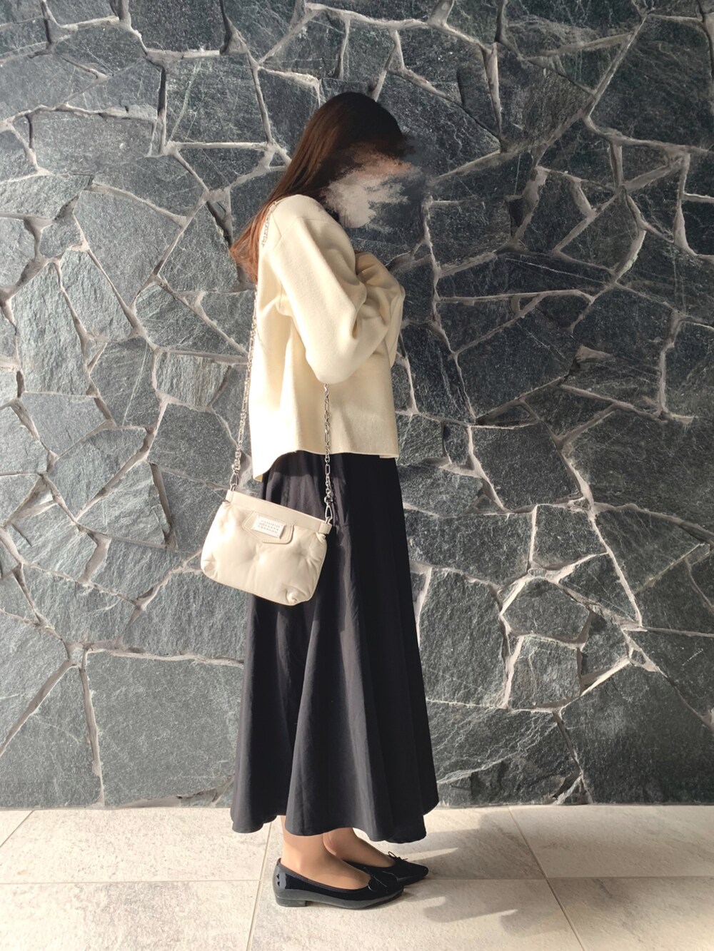 ホワイト系のカーディガン/ボレロ、ブラック系のバレエシューズ、ホワイト系のバッグを着用したレディースの冬コーディネートの2枚目の写真