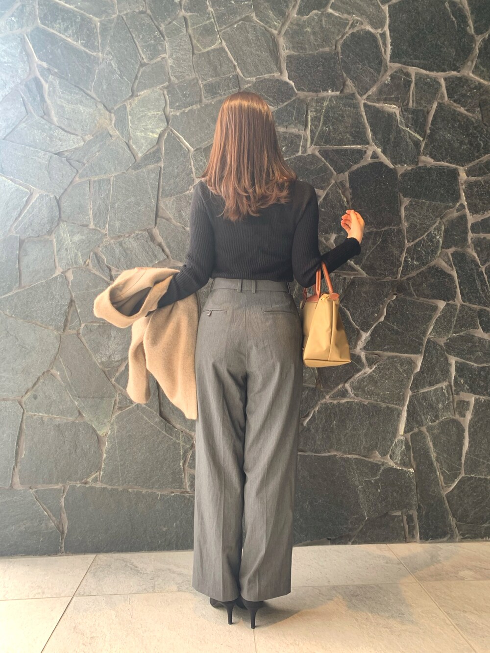 グレー系のパンツ、ブラック系のニット/セーター、ベージュ系のジャケット/アウターを着用したレディースの秋コーディネートの3枚目の写真