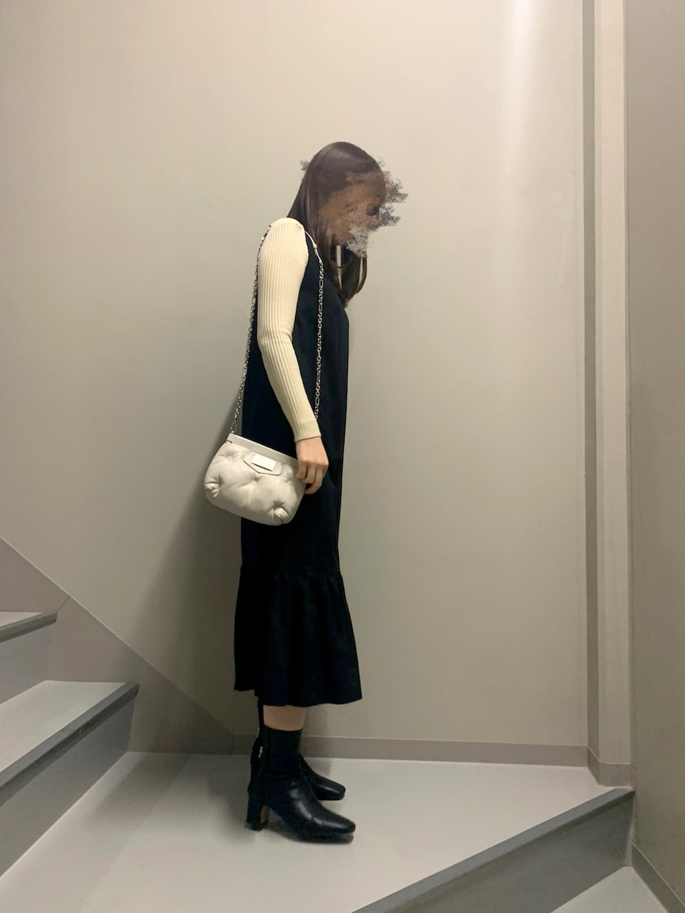 ブラック系のワンピース/ドレス、ベージュ系のニット/セーター、ホワイト系のバッグを着用したレディースの冬コーディネートの3枚目の写真