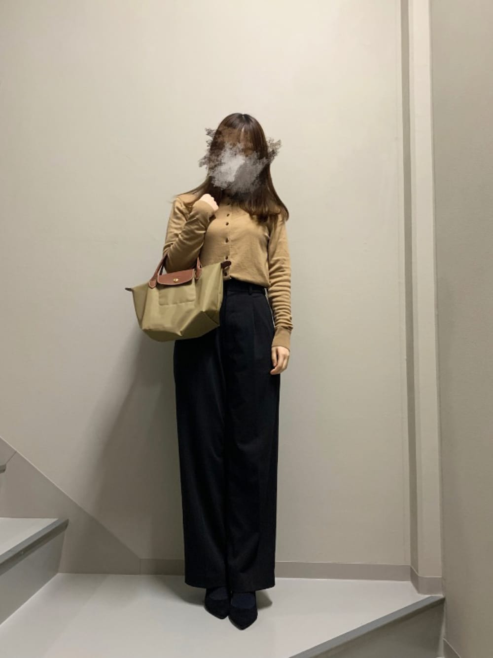 ベージュ系のカーディガン/ボレロ、グレー系のパンツ、ベージュ系のトートバッグを着用したレディースの冬コーディネートの2枚目の写真