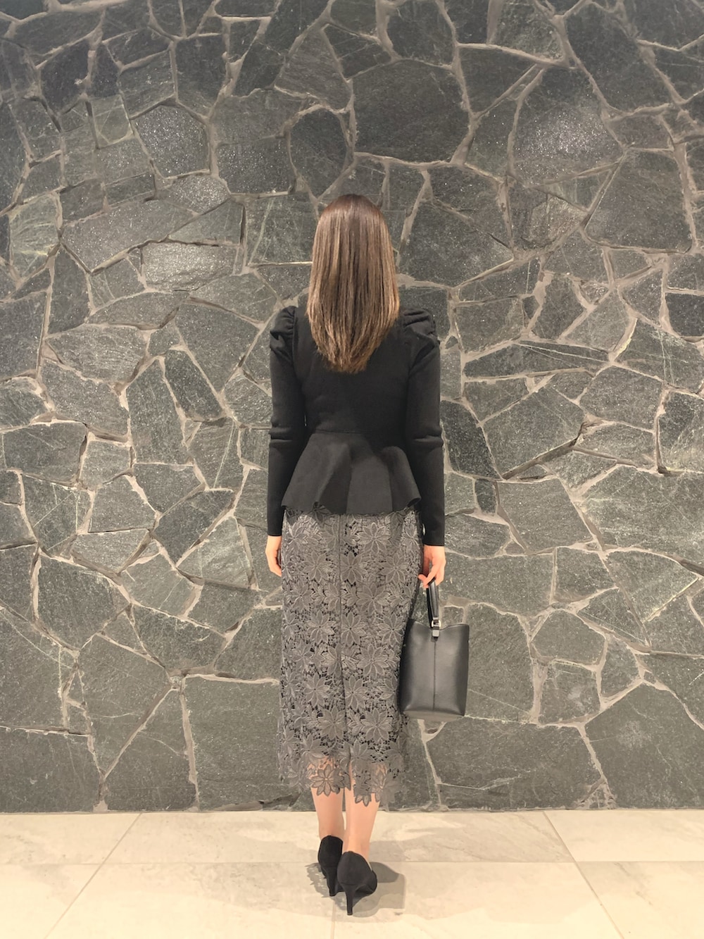 ブラック系のパンプス、ブラック系のニット/セーター、ブラック系のハンドバッグを着用したレディースの秋コーディネートの2枚目の写真