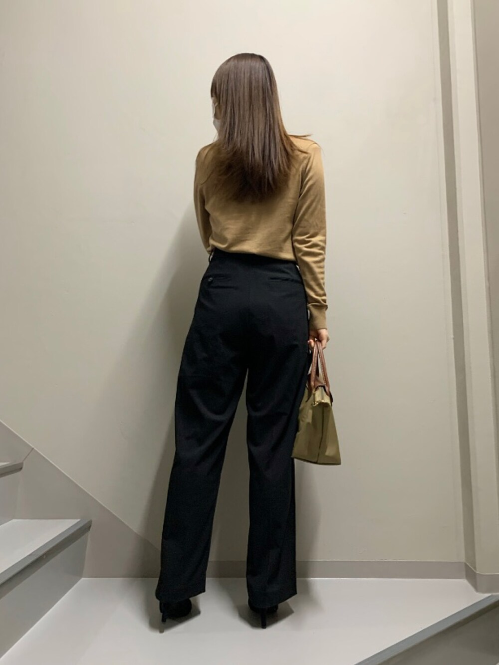 ベージュ系のカーディガン/ボレロ、グレー系のパンツ、ベージュ系のトートバッグを着用したレディースの冬コーディネートの3枚目の写真