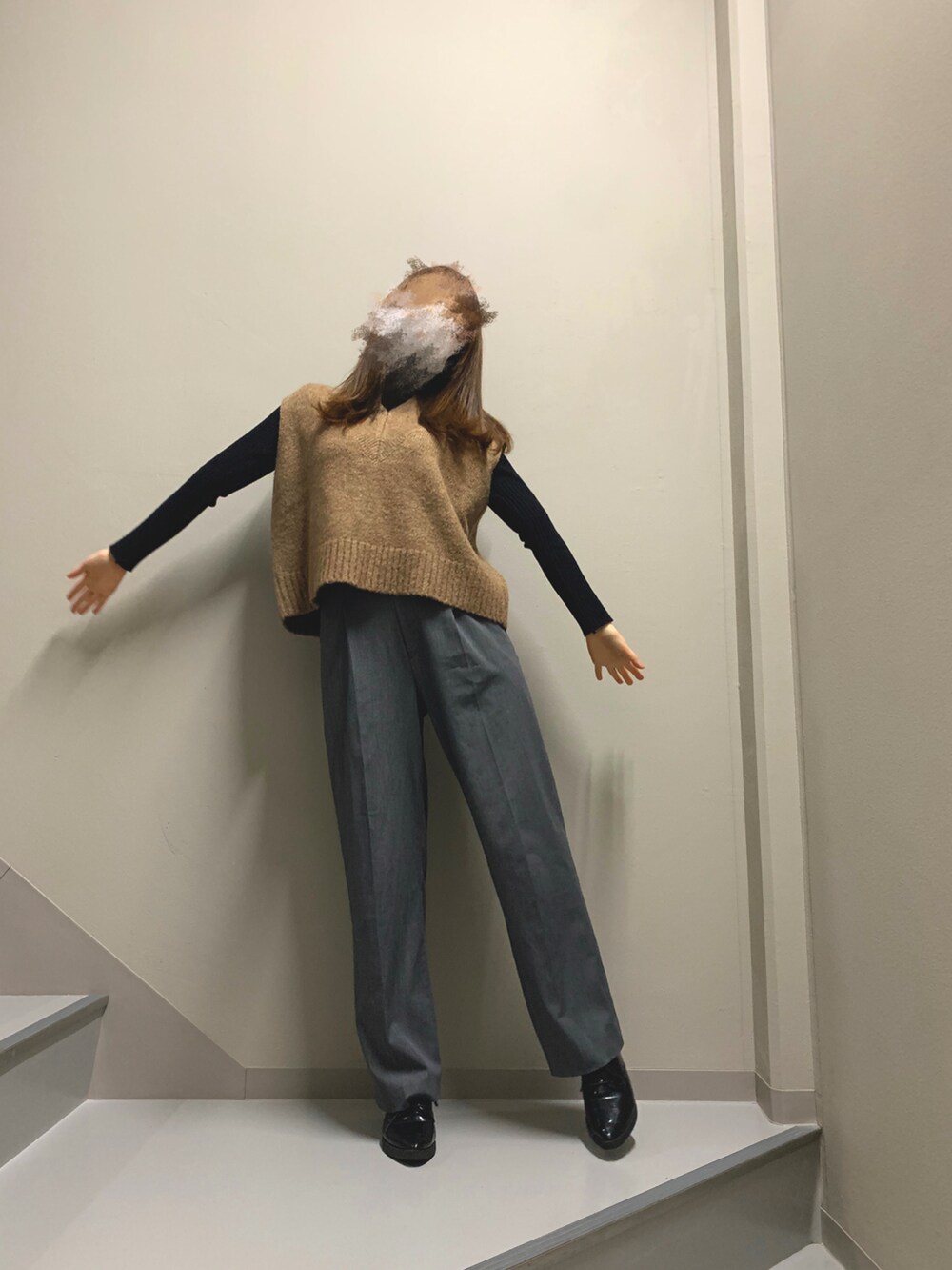 ブラウン系のベスト、グレー系のパンツ、ブラック系のシューズを着用したレディースの冬コーディネートの2枚目の写真