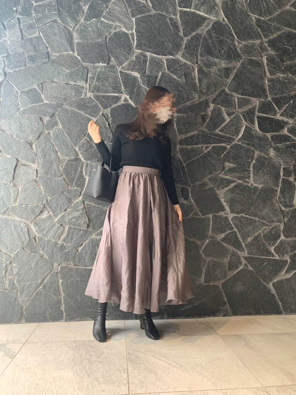 ブラック系のニット/セーター、ブラック系のハンドバッグ、グレー系のスカートを着用したレディースの秋コーディネートの2枚目の写真