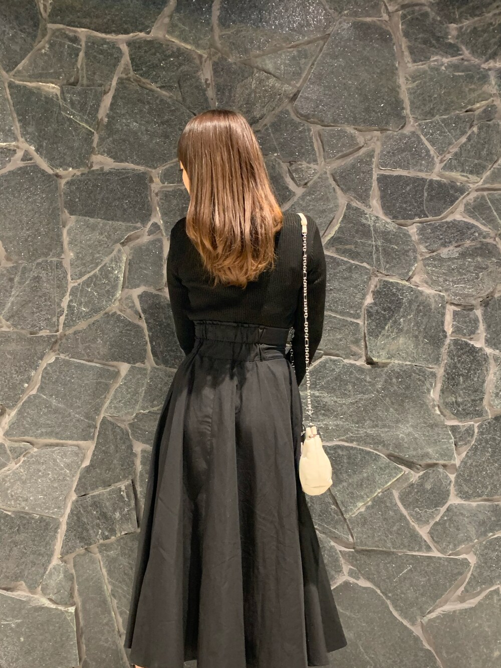 ブラック系のニット/セーター、ブラック系のスカート、ブラウン系のブーツを着用したレディースの冬コーディネートの3枚目の写真