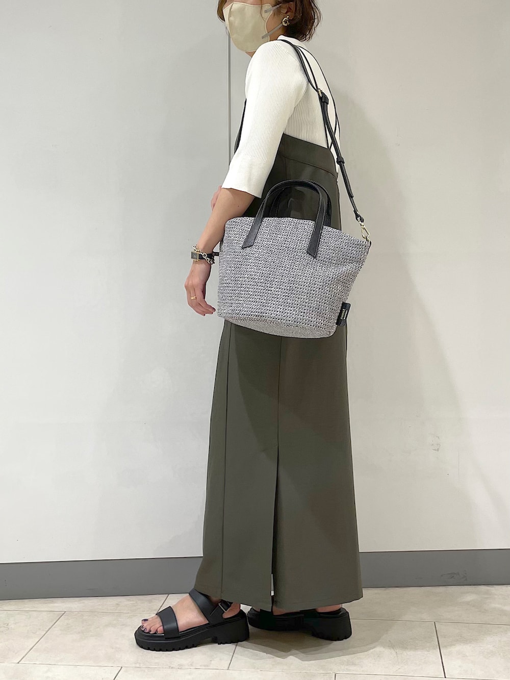 ホワイト系のニット/セーター、グレー系のトートバッグ、ブラック系のサンダルを着用したレディースの春コーディネートの2枚目の写真