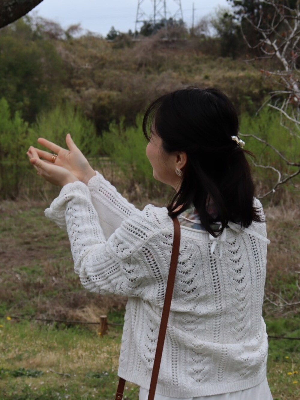 ピンク系のかごバッグ、ホワイト系のワンピース、その他のトップスを着用したレディースの春コーディネートの2枚目の写真