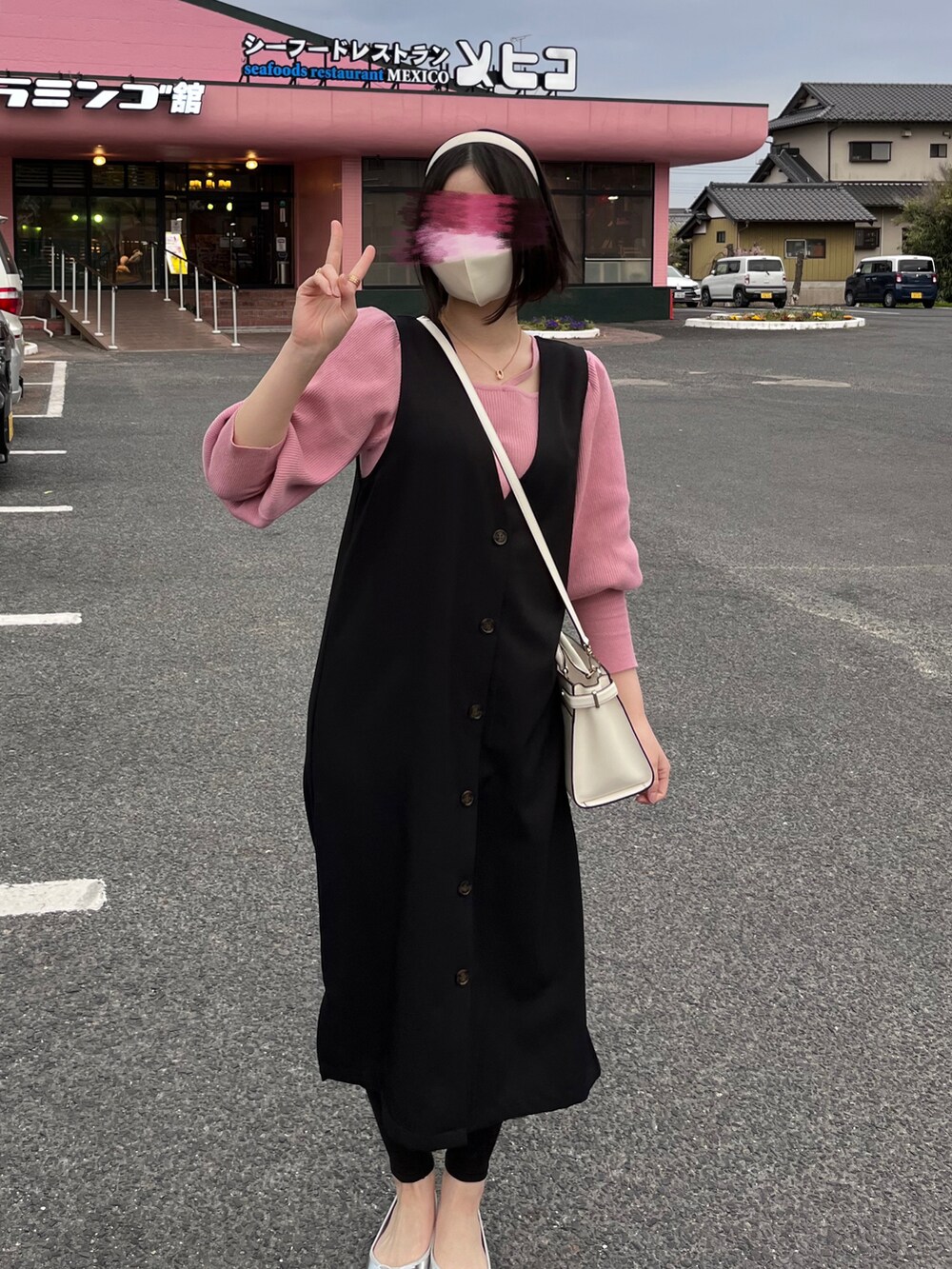 ピンク系のニット/セーター、ブラック系のトップスを着用したレディースの春コーディネートの2枚目の写真
