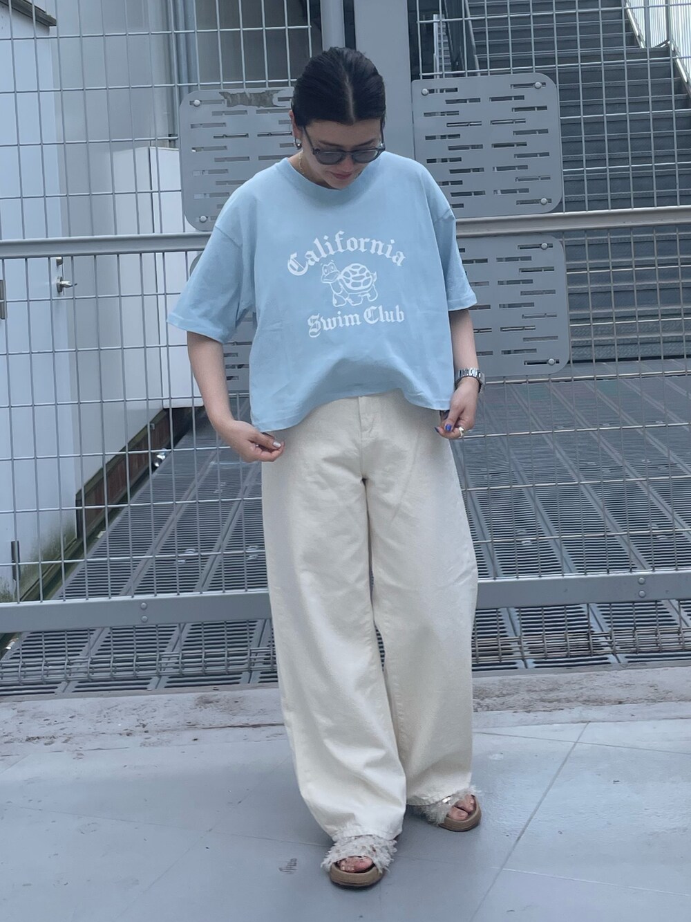 ホワイト系のデニムパンツ、ブルー系のTシャツ/カットソー、グレー系のサングラスを着用したレディースの春コーディネートの4枚目の写真