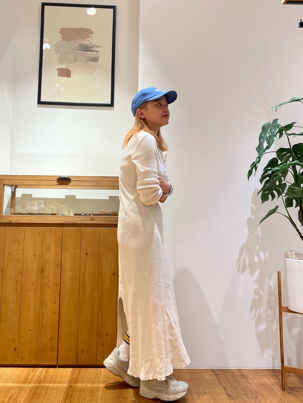 ホワイト系のワンピース、ブルー系のキャップを着用したレディースの春コーディネートの4枚目の写真