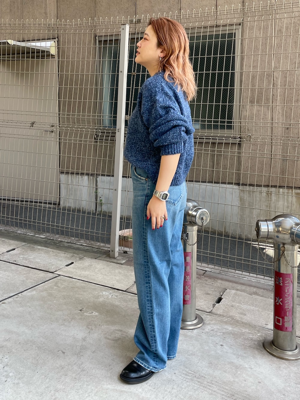 ブルー系のニット/セーター、ブルー系のデニムパンツを着用したレディースの秋コーディネートの2枚目の写真