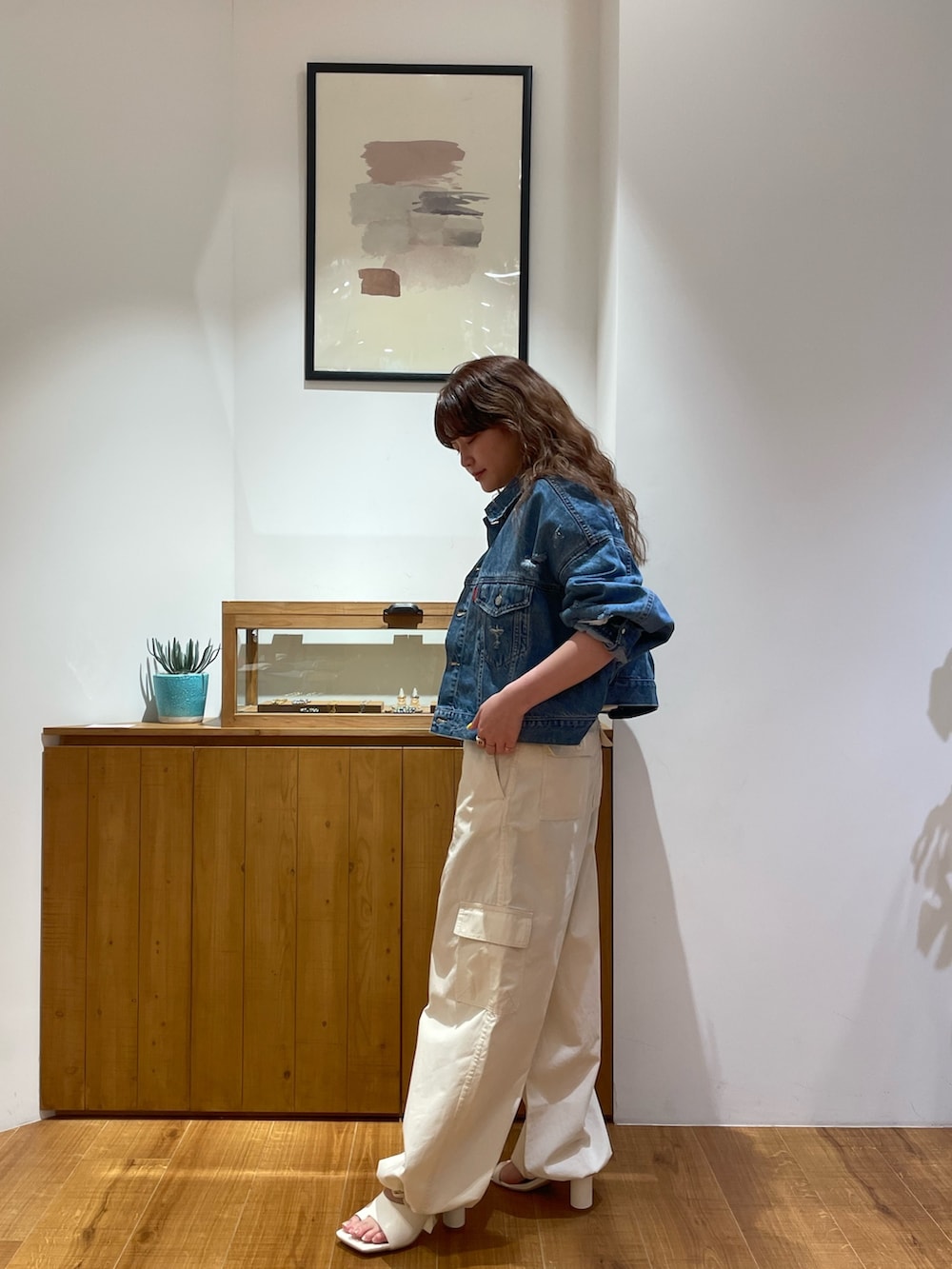 ブルー系のデニムジャケット、ホワイト系のつなぎ/オールインワン、ホワイト系のサンダルを着用したレディースの春コーディネートの2枚目の写真