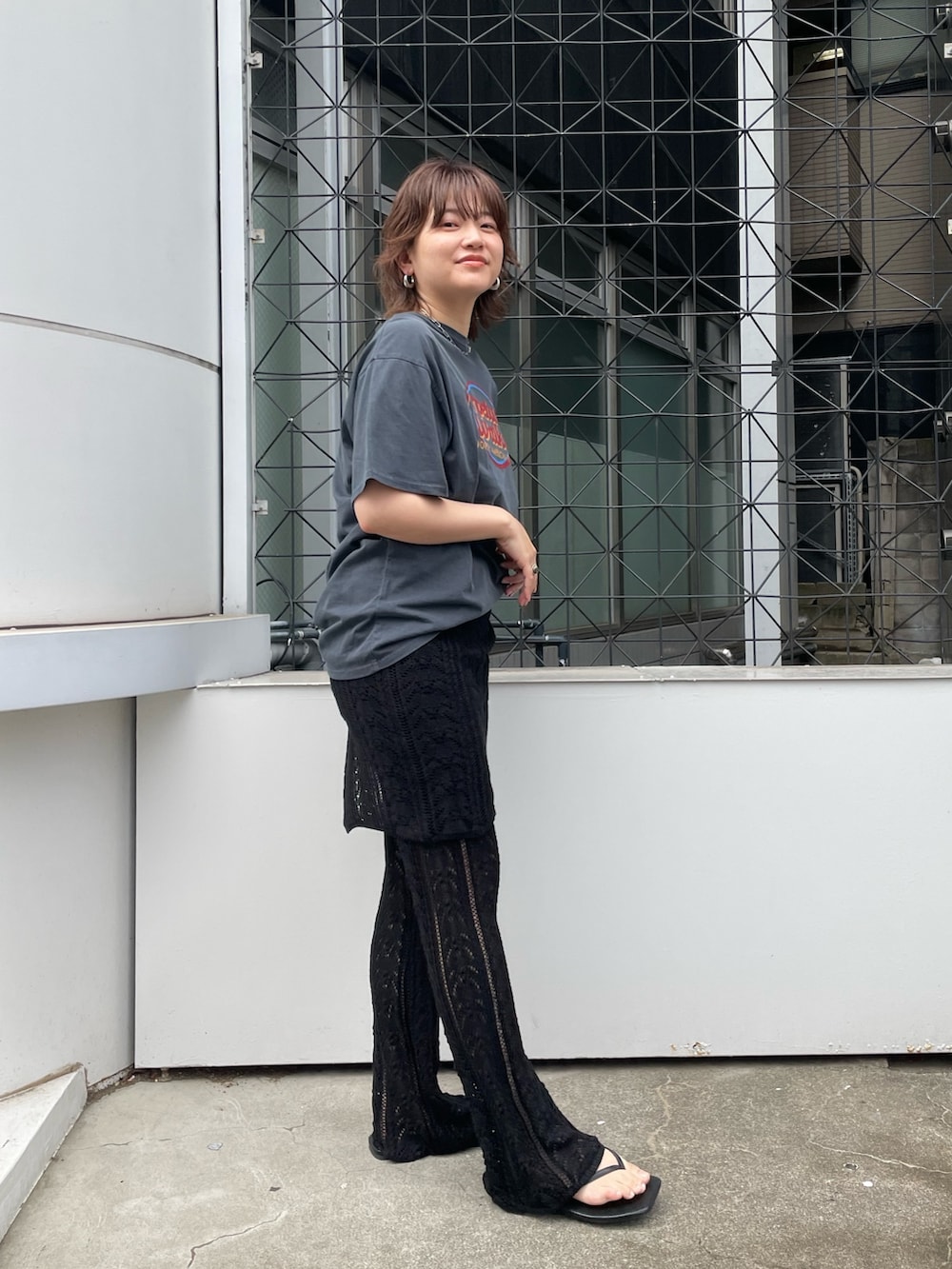 ブラック系のその他パンツ、グレー系のTシャツ/カットソー、ブラック系のサンダルを着用したレディースの春コーディネートの2枚目の写真