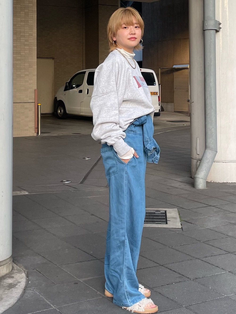 グレー系のスウェット、ホワイト系のTシャツ/カットソー、ブルー系のつなぎ/オールインワンを着用したレディースの冬コーディネートの2枚目の写真