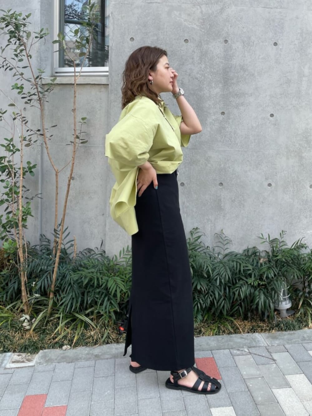 ブラック系のサンダル、グリーン系のシャツ/ブラウス、ブラック系のワンピースを着用したレディースの春コーディネートの2枚目の写真