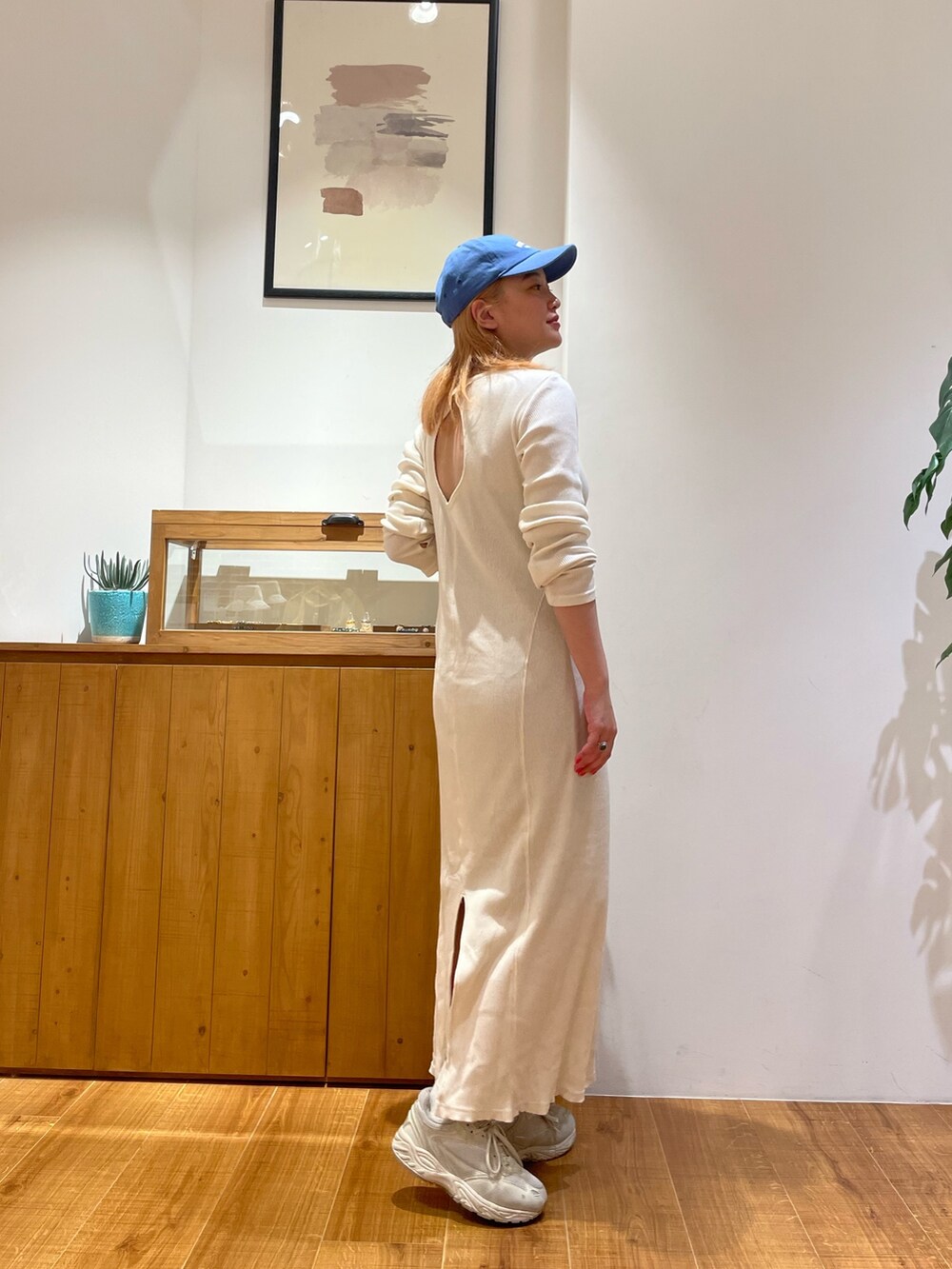 ホワイト系のワンピース、ブルー系のキャップを着用したレディースの春コーディネートの2枚目の写真