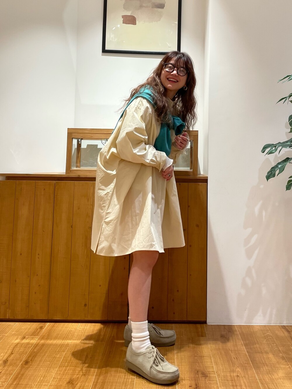 イエロー系のシャツ/ブラウス、グリーン系のTシャツ/カットソー、ブラック系のメガネを着用したレディースの冬コーディネートの2枚目の写真