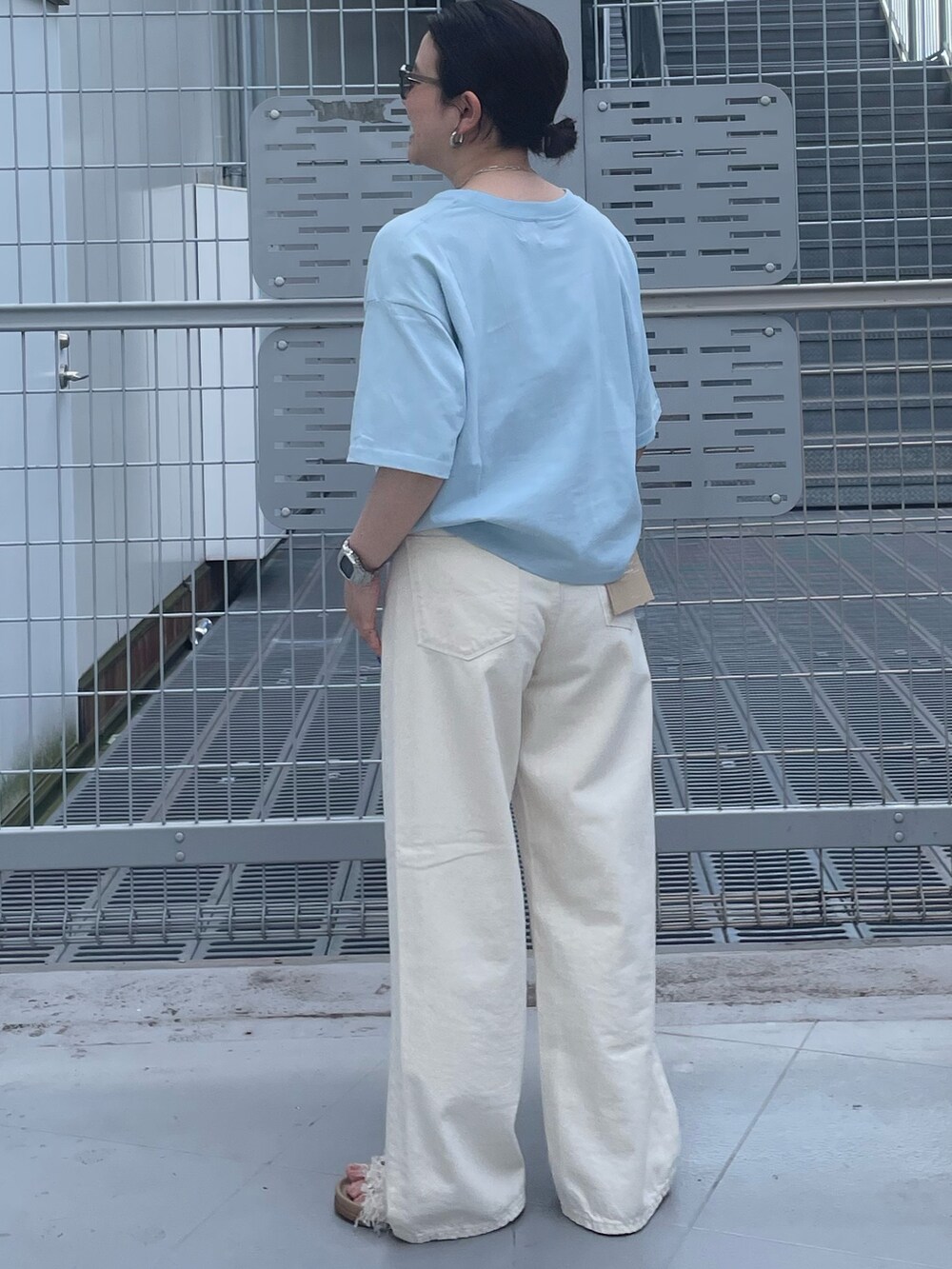 ホワイト系のデニムパンツ、ブルー系のTシャツ/カットソー、グレー系のサングラスを着用したレディースの春コーディネートの3枚目の写真