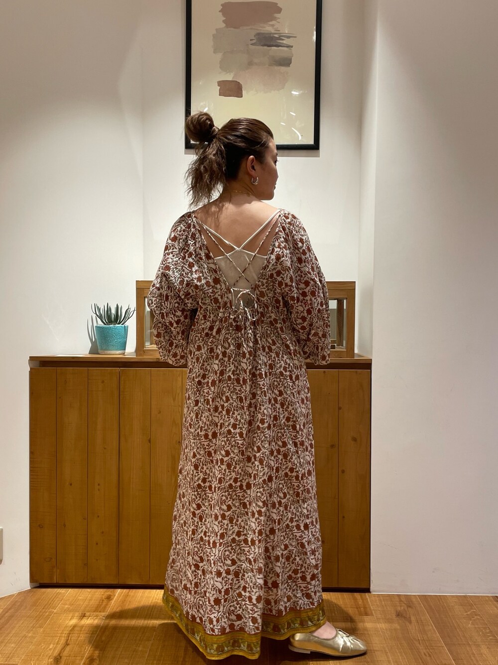 ホワイト系のワンピース、ゴールド系のパンプス、ゴールド系のネックレスを着用したレディースの春コーディネートの3枚目の写真