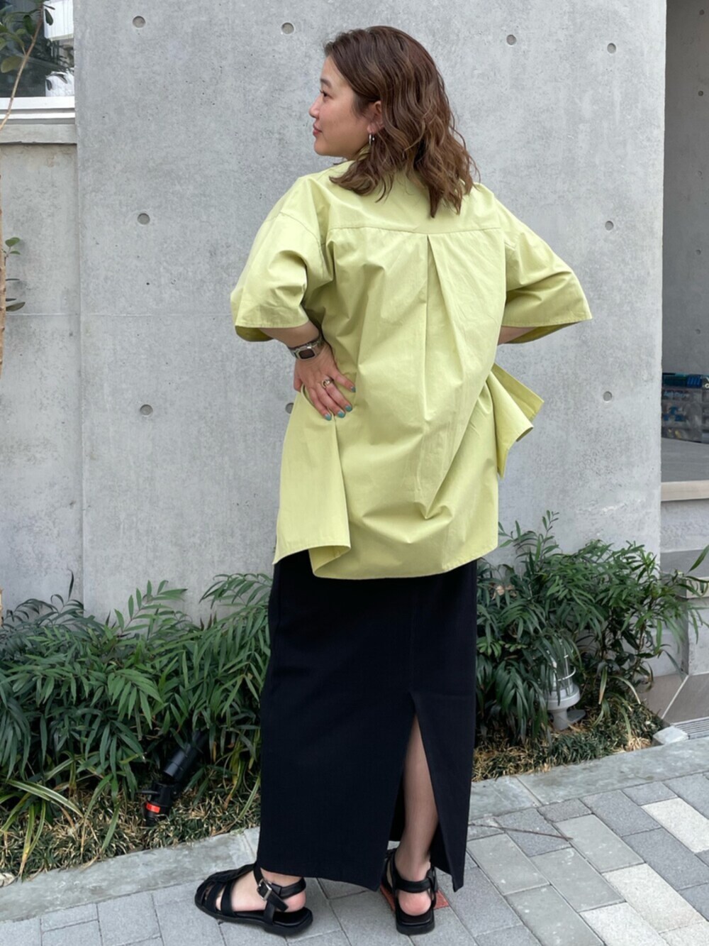 ブラック系のサンダル、グリーン系のシャツ/ブラウス、ブラック系のワンピースを着用したレディースの春コーディネートの3枚目の写真