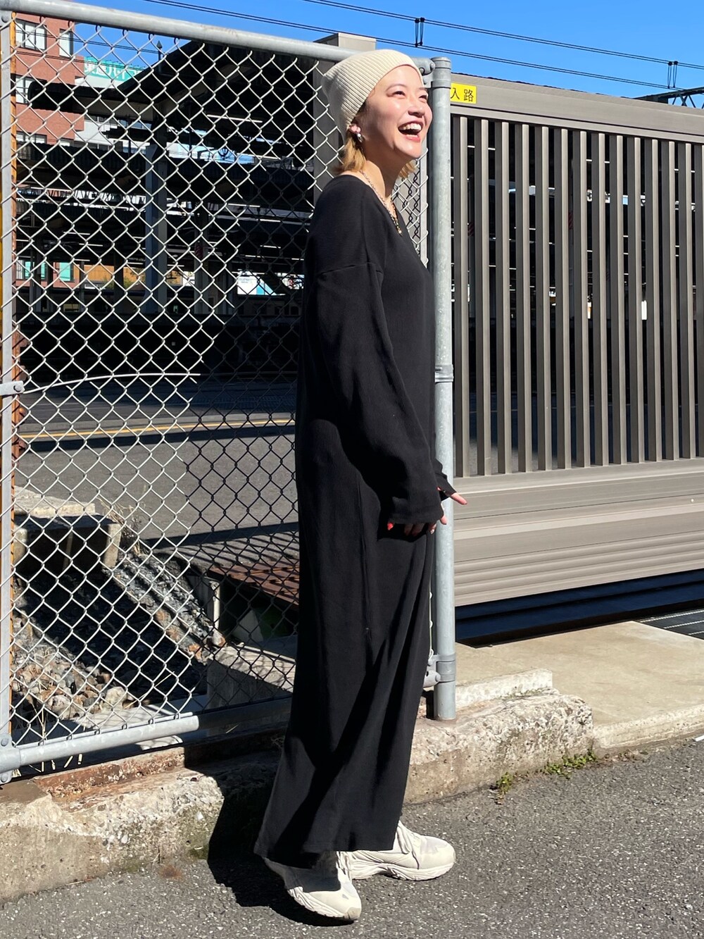 ブラック系のワンピース、ホワイト系のニットキャップ/ビーニーを着用したレディースの春コーディネートの2枚目の写真