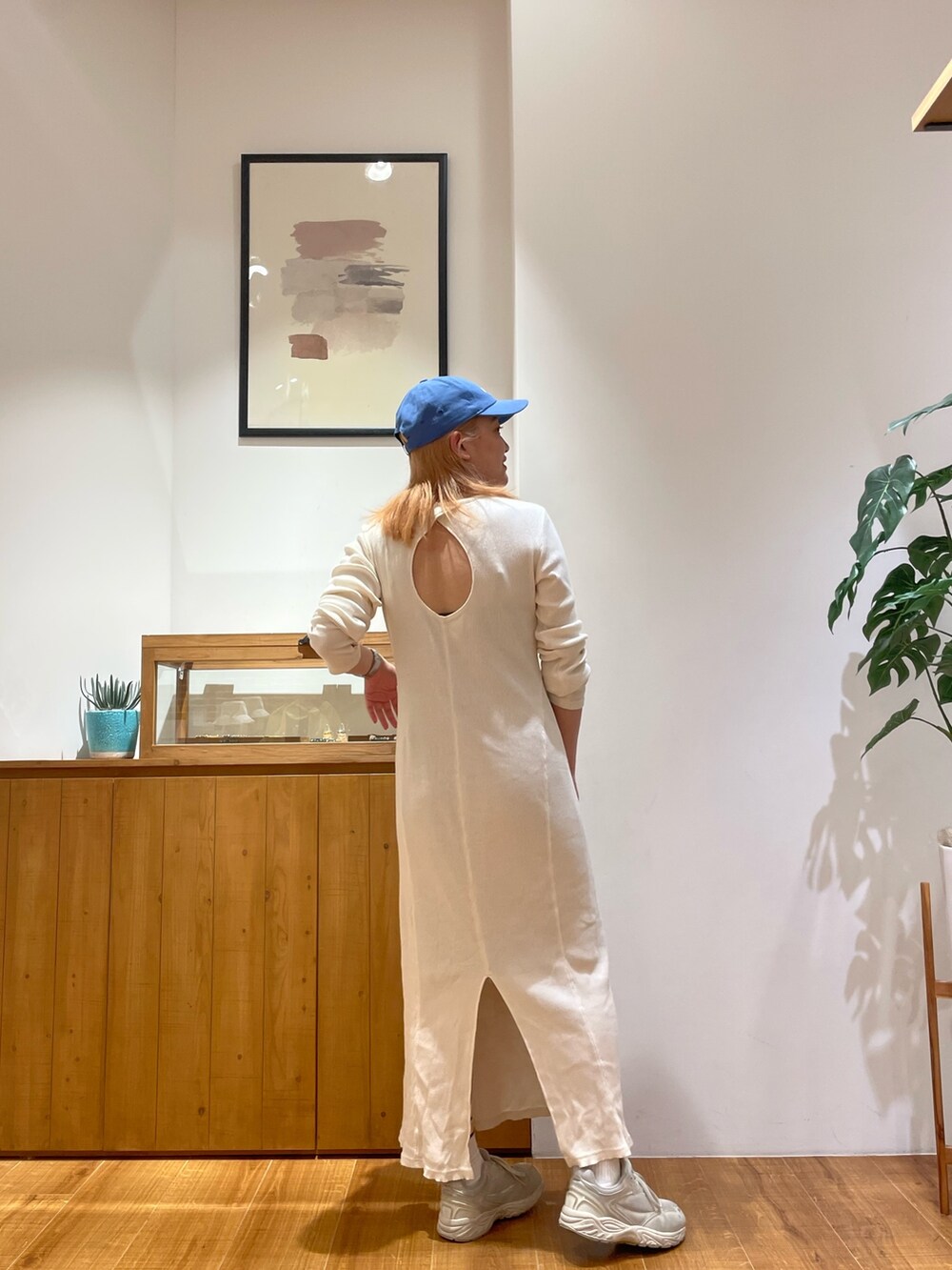 ホワイト系のワンピース、ブルー系のキャップを着用したレディースの春コーディネートの3枚目の写真