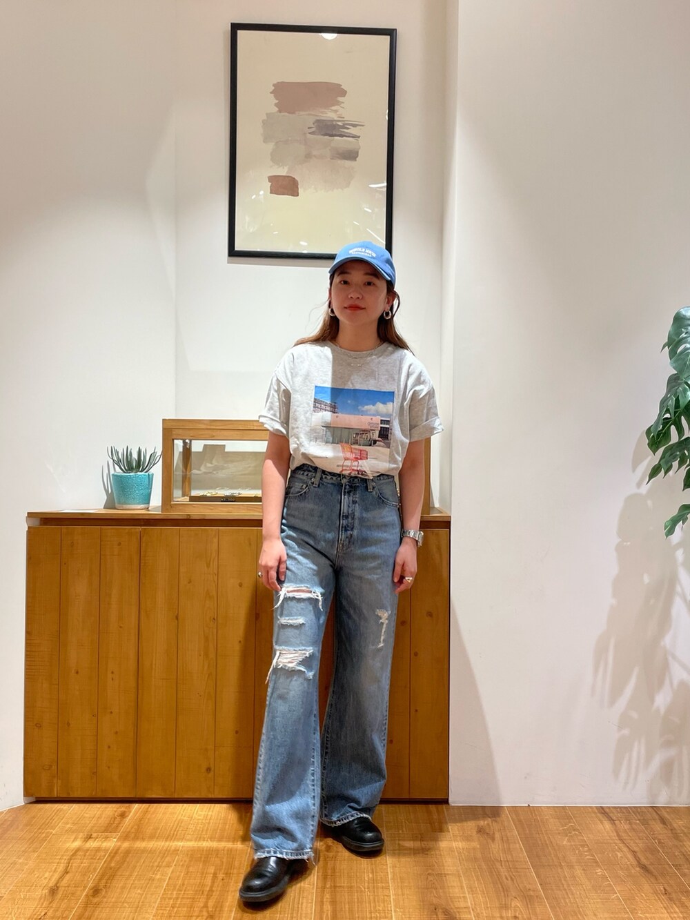 グレー系のTシャツ/カットソー、ブルー系のデニムパンツ、ブルー系のキャップを着用したレディースの春コーディネートの2枚目の写真