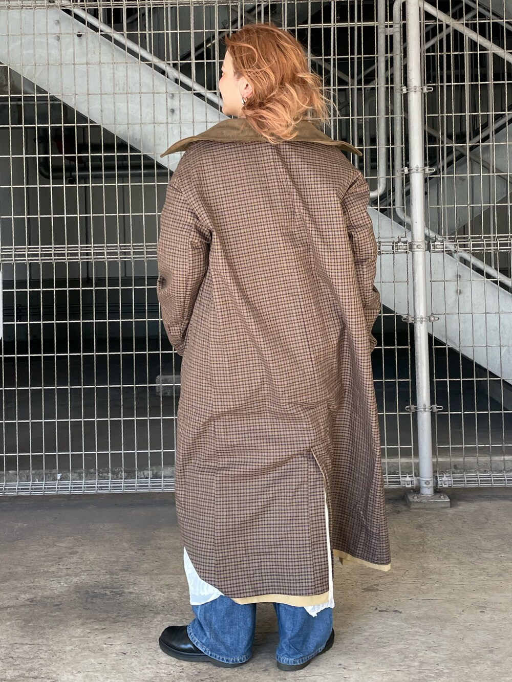 ベージュ系のステンカラーコート、グレー系のスウェット、ホワイト系のワンピースを着用したレディースの秋コーディネートの3枚目の写真