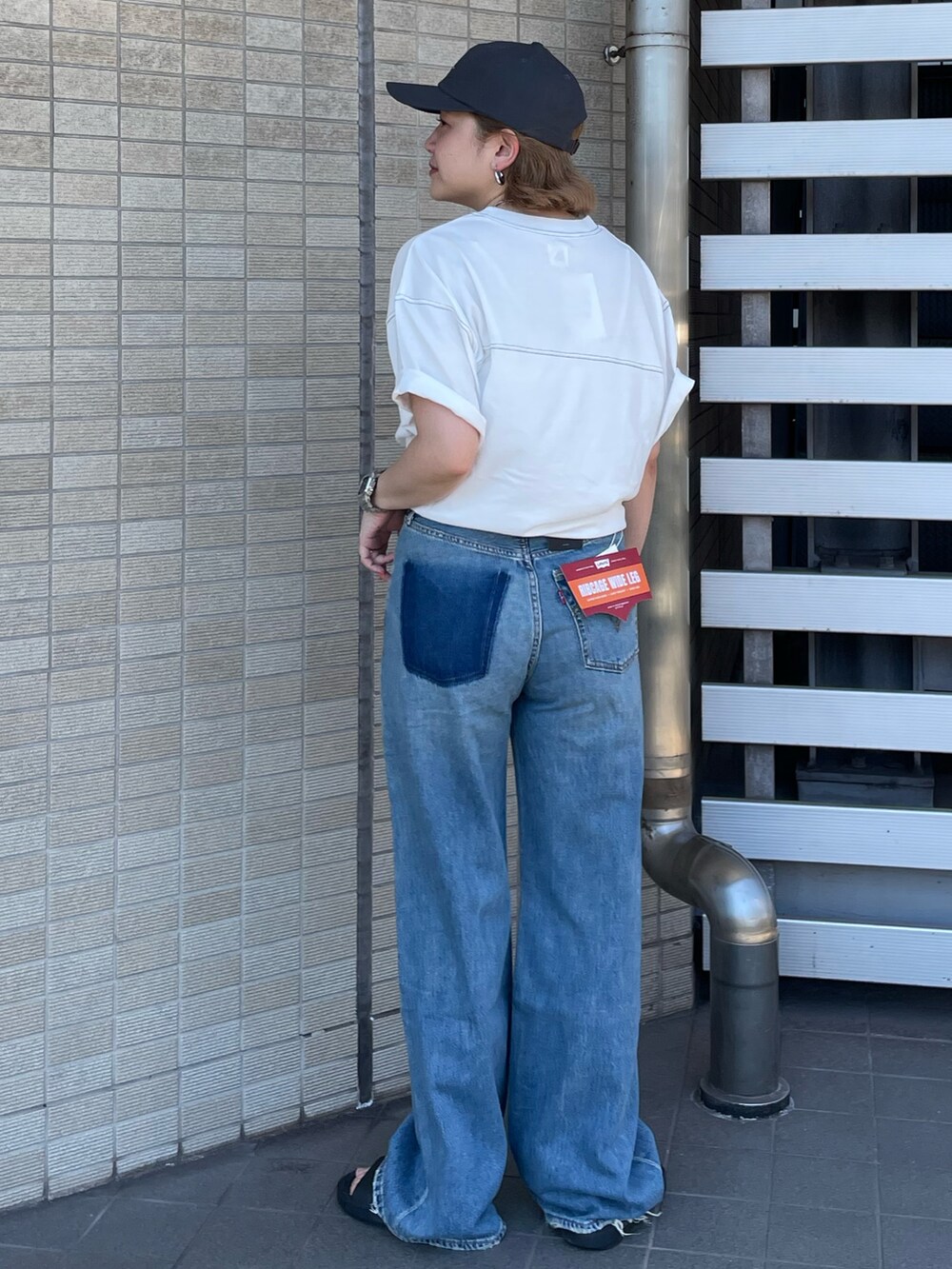 ホワイト系のTシャツ/カットソー、ブルー系のデニムパンツ、グレー系のキャップを着用したレディースの夏コーディネートの3枚目の写真