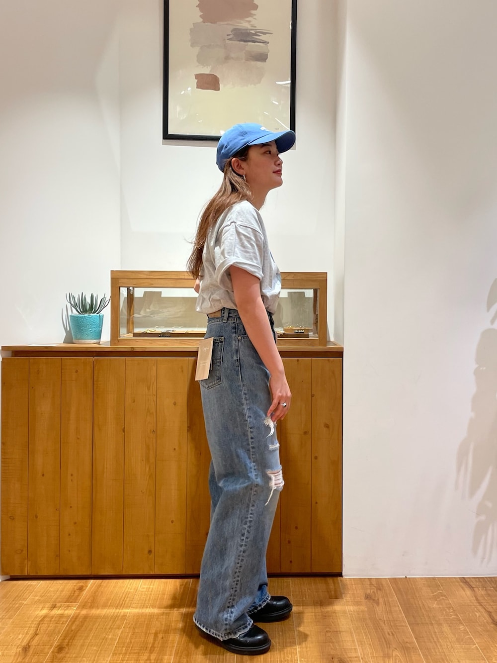 グレー系のTシャツ/カットソー、ブルー系のデニムパンツ、ブルー系のキャップを着用したレディースの春コーディネートの4枚目の写真