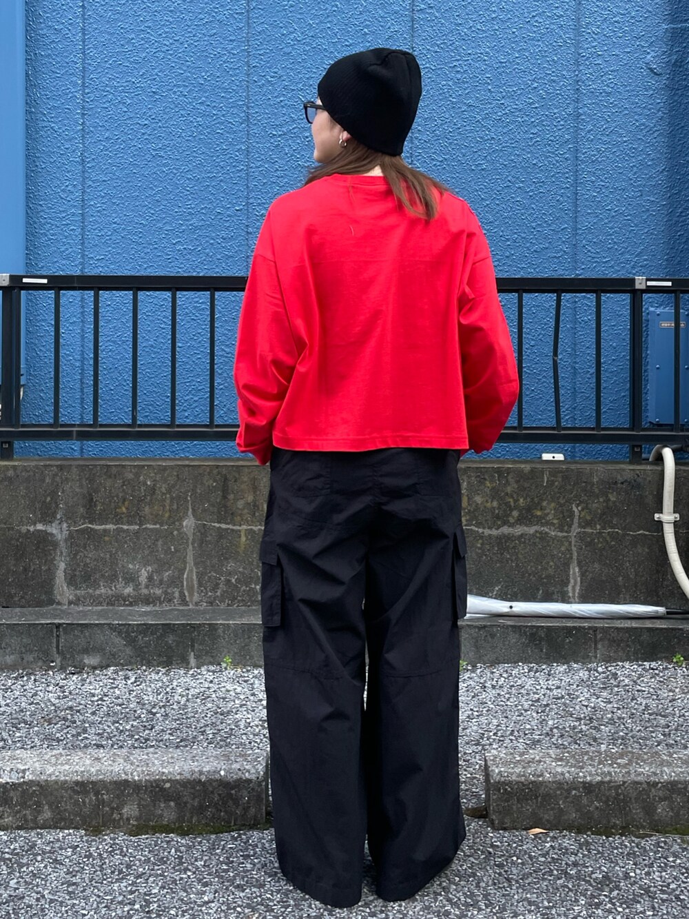 レッド系のTシャツ/カットソー、ブラック系のその他パンツ、ブラック系のニットキャップ/ビーニーを着用したレディースの冬コーディネートの3枚目の写真