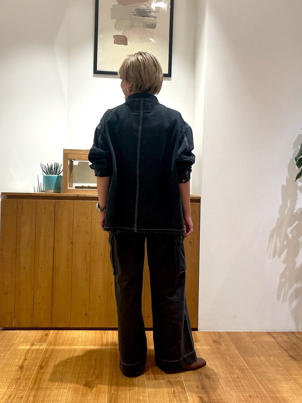 ブラック系のブルゾン、ブラック系のデニムパンツ、イエロー系のキャミソールを着用したレディースの秋コーディネートの3枚目の写真