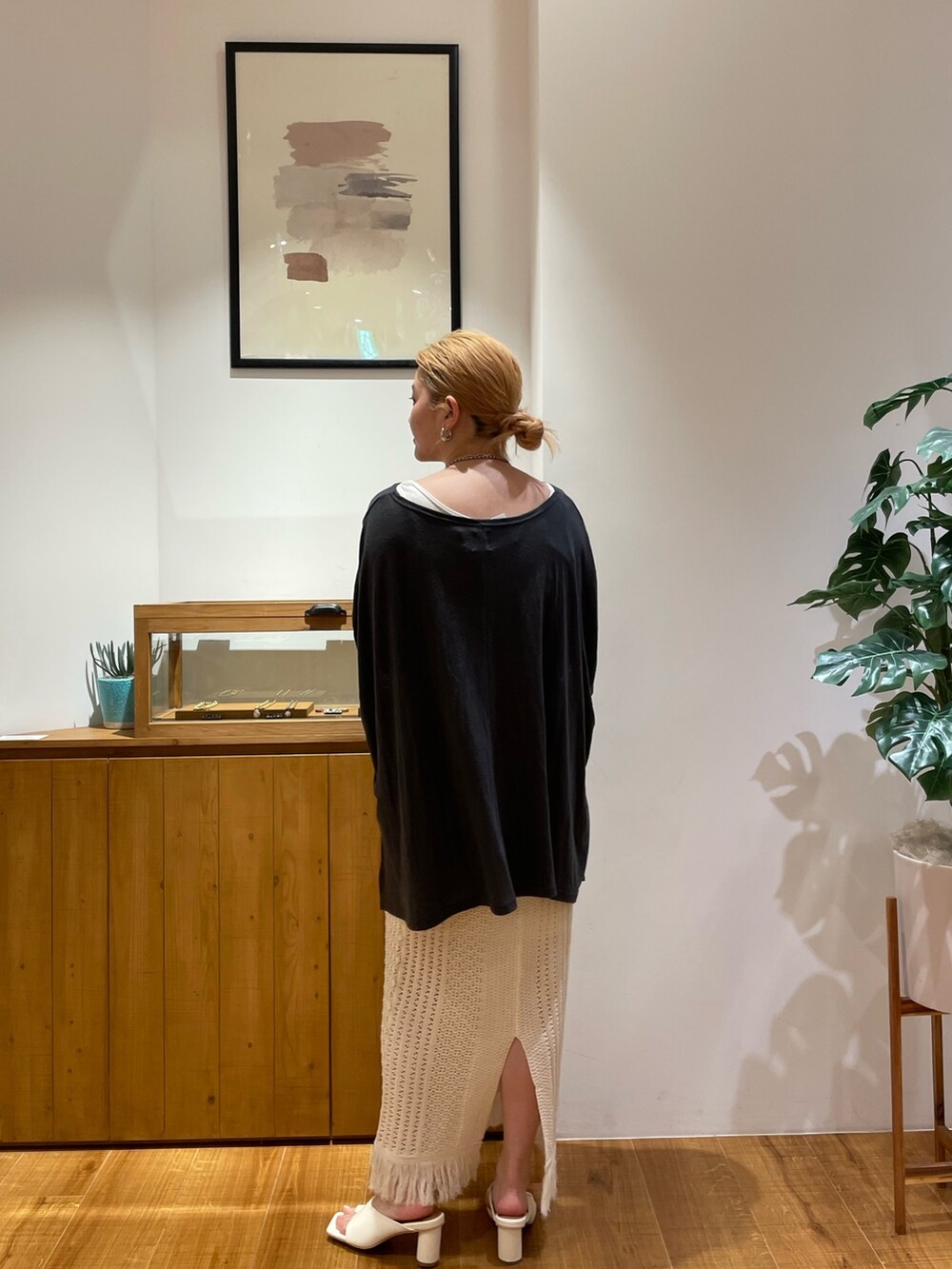 グレー系のTシャツ/カットソー、ホワイト系のスカート、ホワイト系のサンダルを着用したレディースの春コーディネートの3枚目の写真