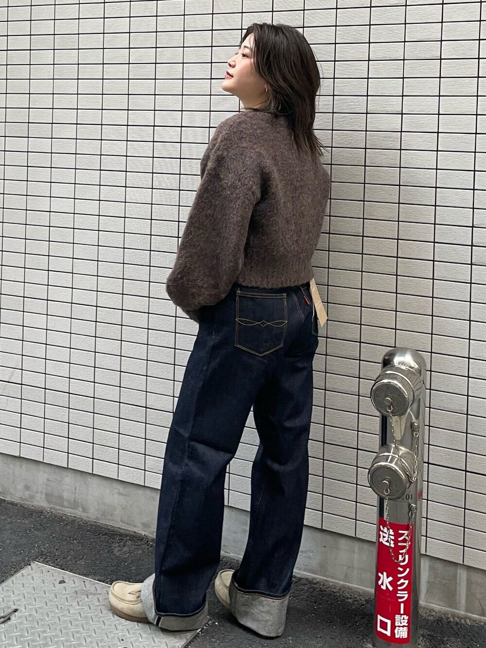 ブルー系のデニムパンツ、グレー系のカーディガン/ボレロを着用したレディースの冬コーディネートの2枚目の写真