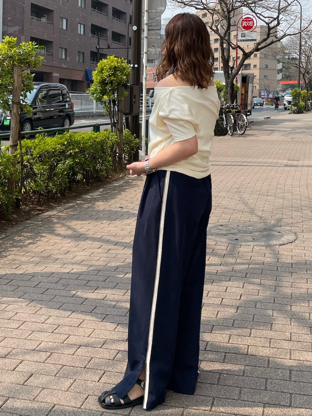 ホワイト系のTシャツ/カットソー、ブルー系のその他パンツ、ブラック系のサンダルを着用したレディースの春コーディネートの2枚目の写真