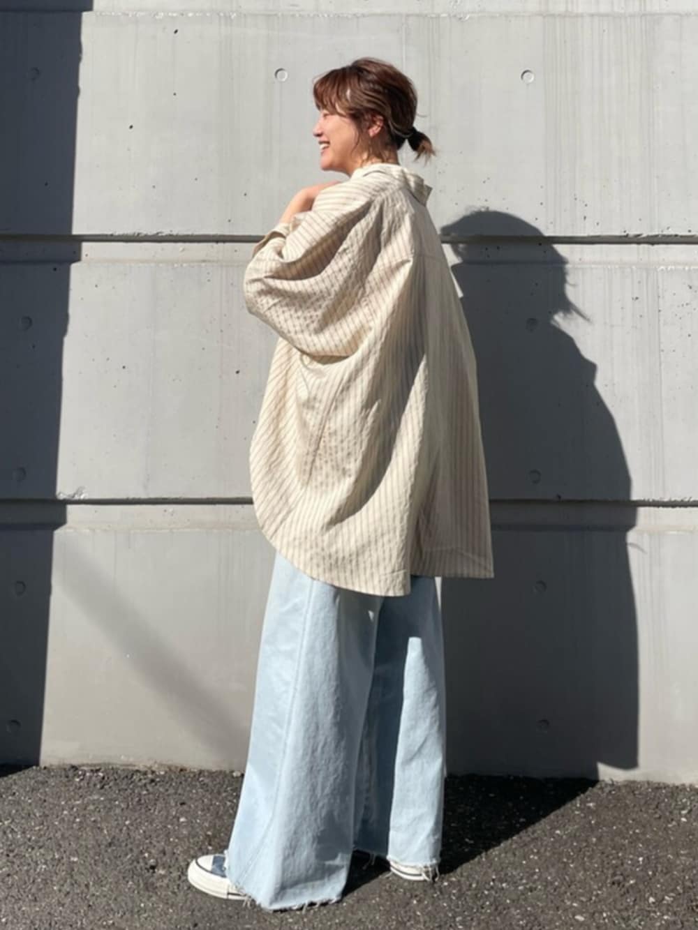 ブルー系のデニムパンツ、ブルー系のスニーカー、イエロー系のシャツ/ブラウスを着用したレディースの春コーディネートの2枚目の写真