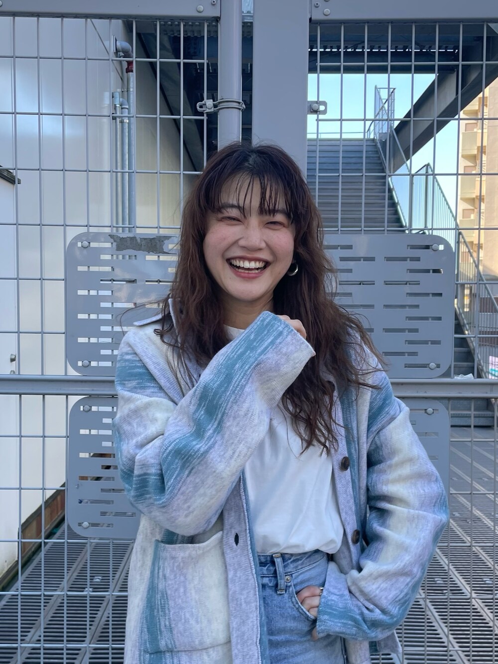 グリーン系のカーディガン/ボレロ、ブルー系のデニムパンツを着用したレディースの冬コーディネートの2枚目の写真