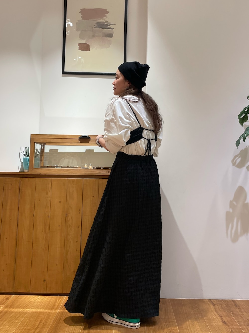 ブラック系のワンピース、ホワイト系のTシャツ/カットソー、グリーン系のスニーカーを着用したレディースの冬コーディネートの3枚目の写真