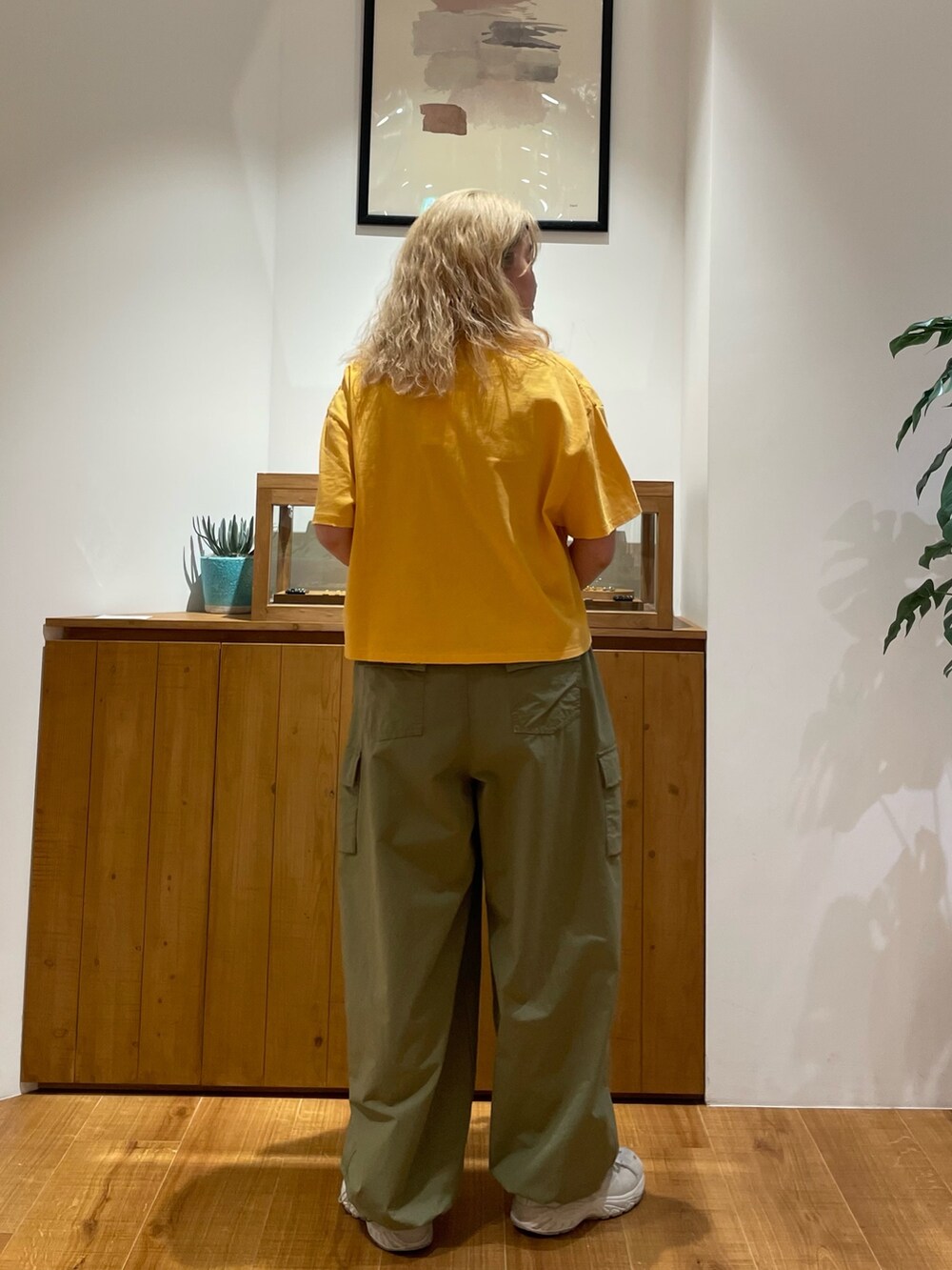 イエロー系のTシャツ/カットソー、グリーン系のカーゴパンツを着用したレディースの春コーディネートの2枚目の写真