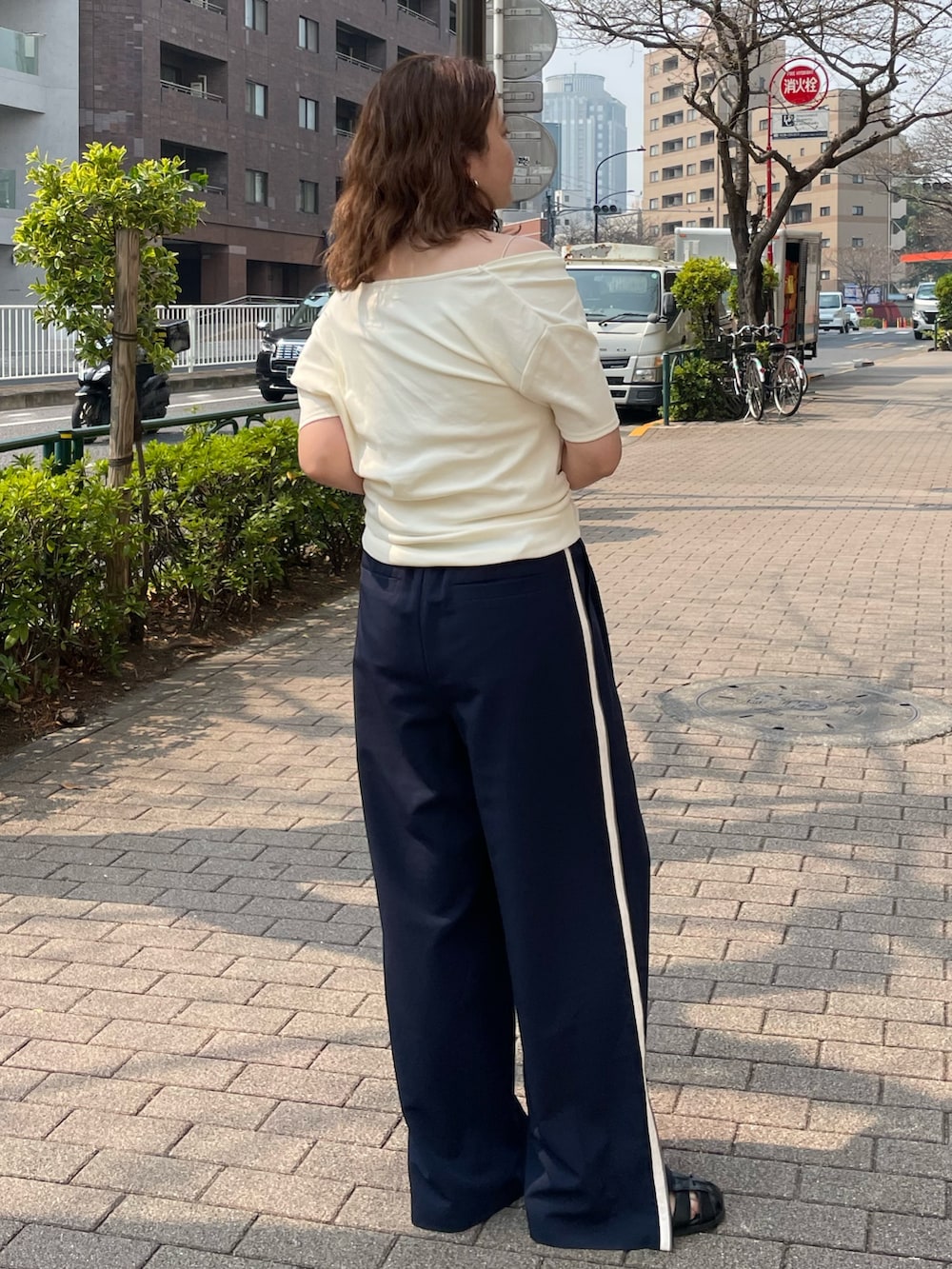 ホワイト系のTシャツ/カットソー、ブルー系のその他パンツ、ブラック系のサンダルを着用したレディースの春コーディネートの4枚目の写真