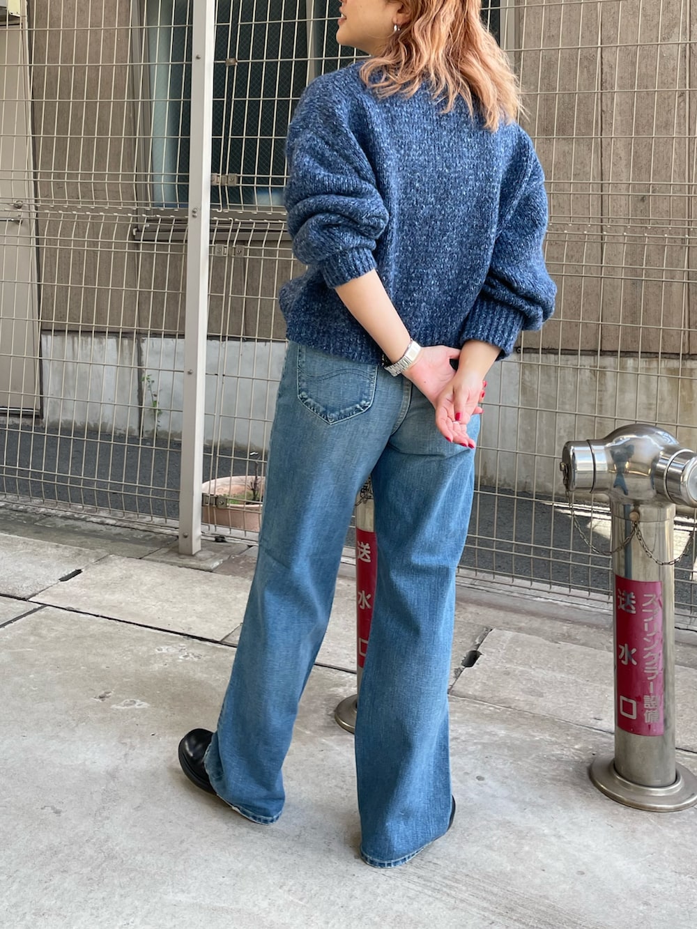ブルー系のニット/セーター、ブルー系のデニムパンツを着用したレディースの秋コーディネートの3枚目の写真