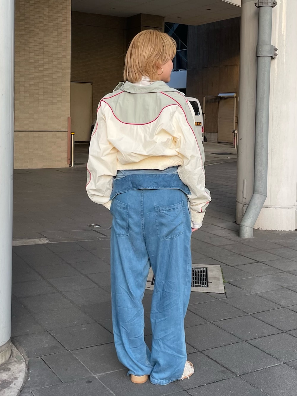 ホワイト系のブルゾン、パープル系のTシャツ/カットソー、ブルー系のつなぎ/オールインワンを着用したレディースの冬コーディネートの3枚目の写真