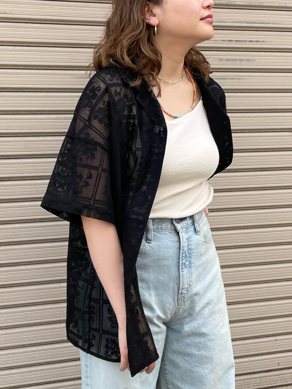 ブラック系のシャツ/ブラウス、ホワイト系のキャミソール、ブルー系のデニムパンツを着用したレディースの春コーディネートの4枚目の写真