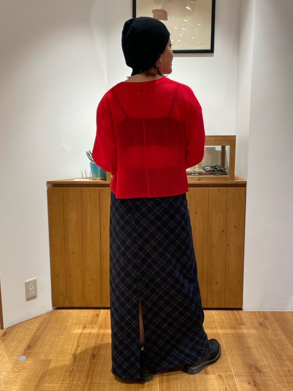 レッド系のニット/セーター、ブルー系のスカートを着用したレディースの秋コーディネートの3枚目の写真