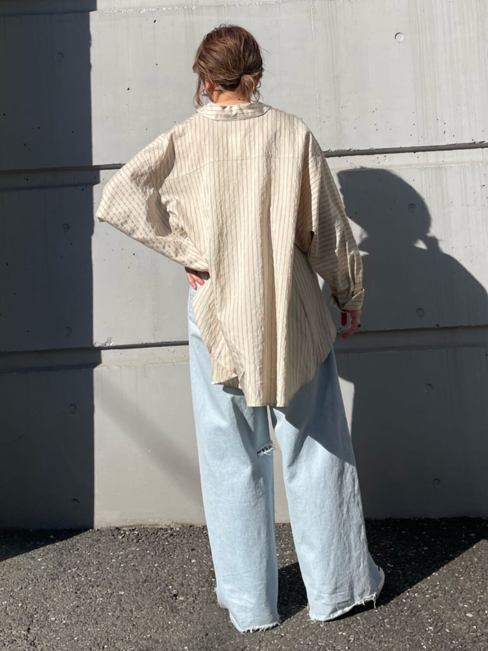 ブルー系のデニムパンツ、ブルー系のスニーカー、イエロー系のシャツ/ブラウスを着用したレディースの春コーディネートの3枚目の写真